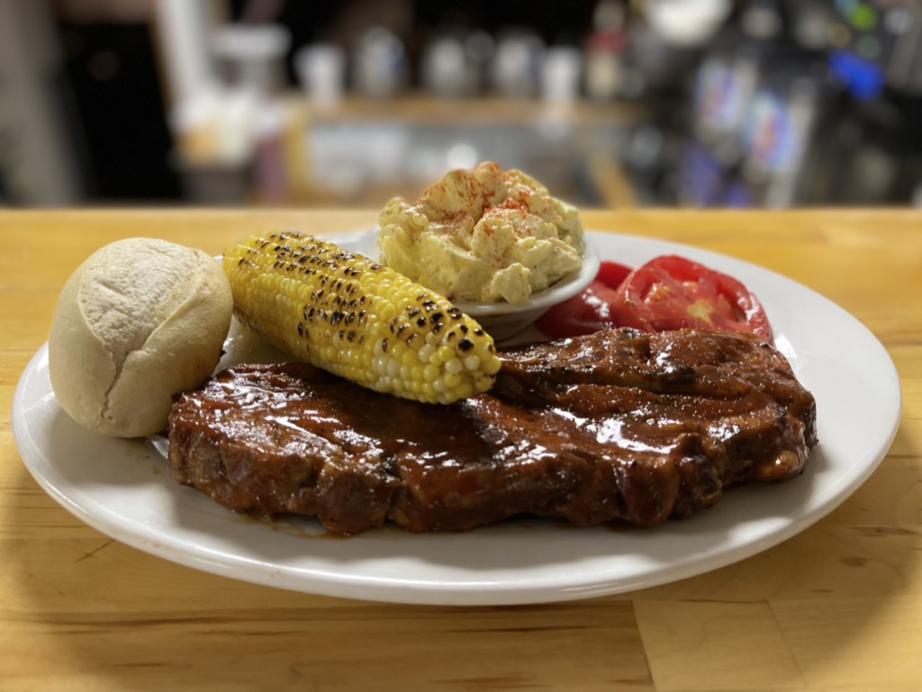 Saturday BBQ pork steak plate with corn and potato salad