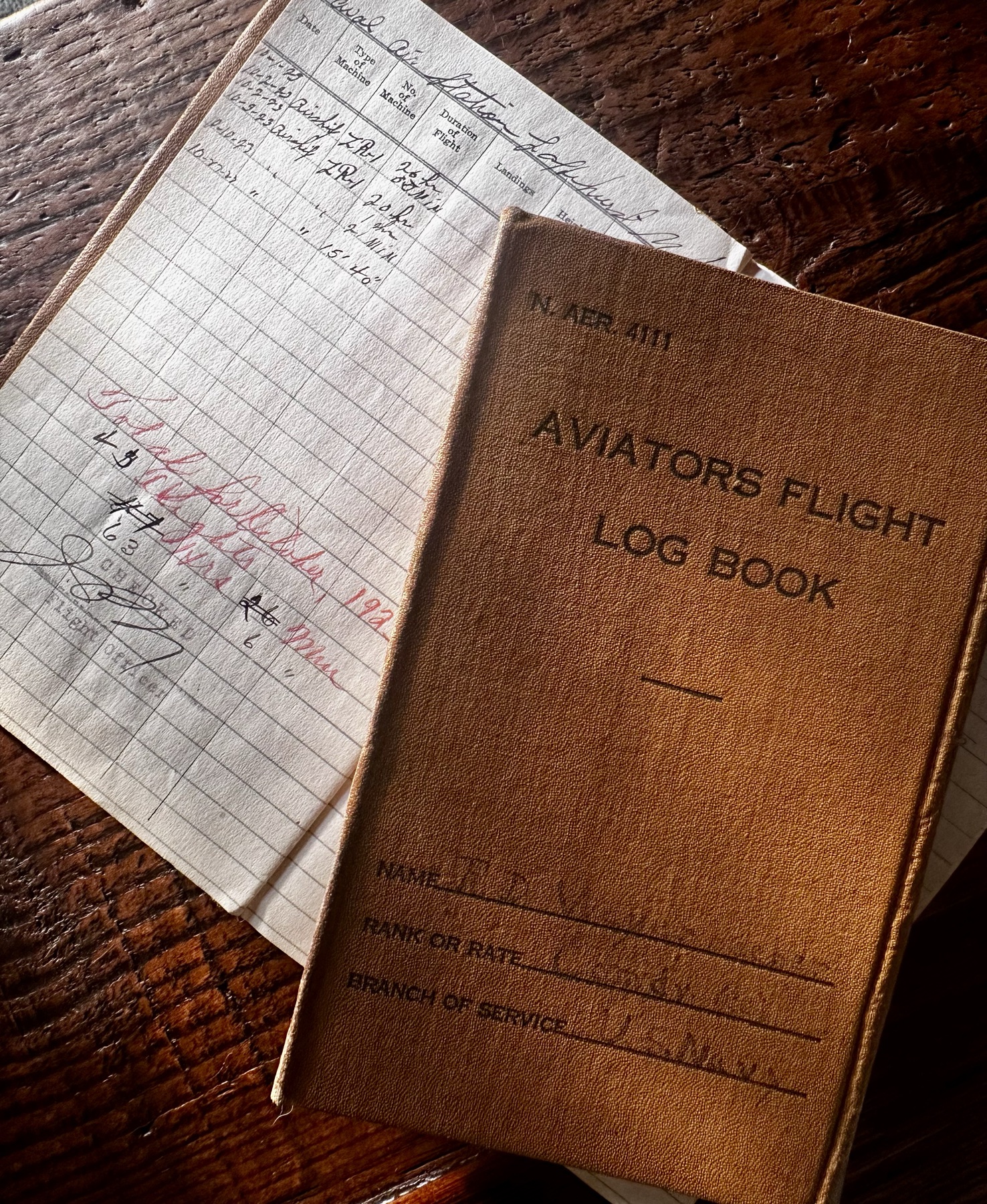 A real aviator's flight log book, embossed 'Aviators Flight Log Book,' open on handwritten flight records for Airship ZR-1